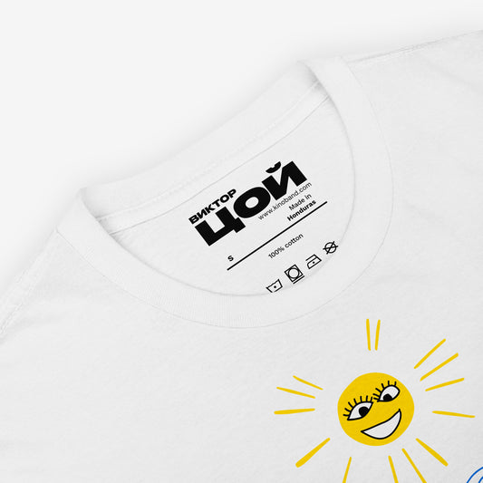 Official KINO band white unisex T-shirt with painting by Viktor Tsoi 'Sun of Beach'. With smiley sun and people on the beach by the water. Closeup photo with necktag logo 'Viktor Tsoi' (Виктор Цой) in Cyrillic. From www.kinoband.com