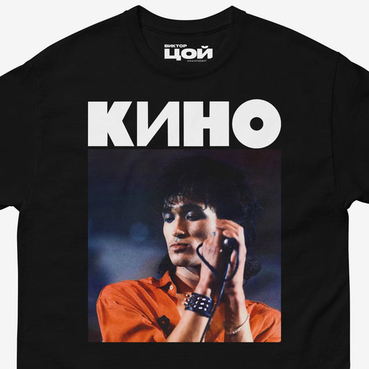 Black unisex t-shirt with a large photo of Viktor Tsoi performing live and bold KINO band logo above. Closeup photo. From kinoband.com