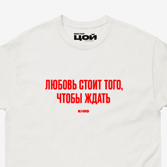 White T-shirt with KINO band lyrics “Любовь стоит того, чтобы ждать”. Closeup photo with visible necktag design. Original Viktor Tsoi merch from www.kinoband.com