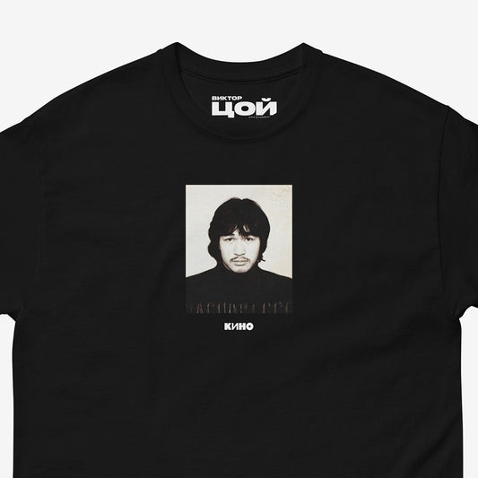 Rare Viktor Tsoi passport photo with a small KINO band logo underneath it, on the front of a heavyweight black unisex t-shirt, from www.kinoband.com. Closeup photo.