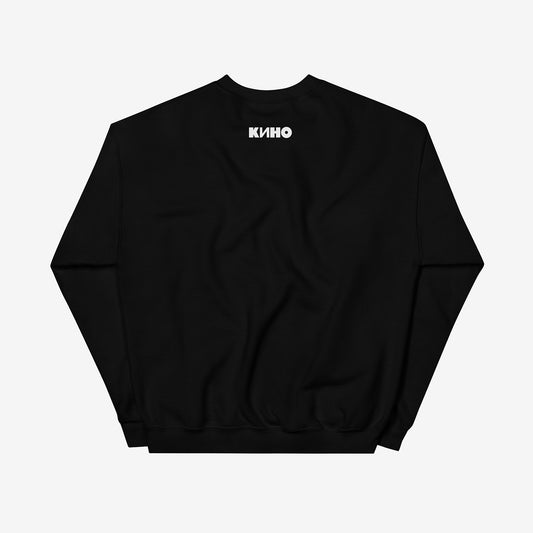 Rare archival photo of Viktor Tsoi in a yellow T-shirt against a white brick wall with a little KINO logo underneath, printed on the front of a heavyweight black unisex sweatshirt with a KINO logo on the back neck side, from www.kinoband.com. Back side.