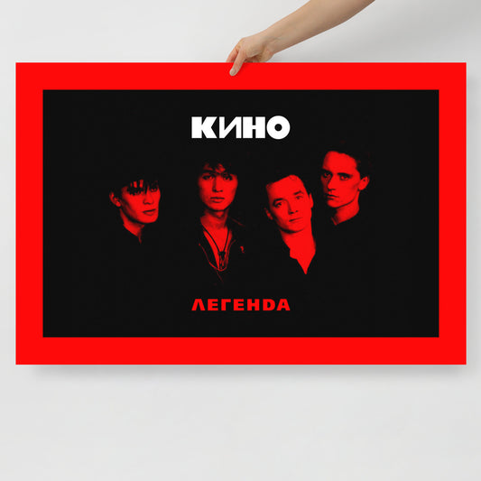 A hand holds large 62x91cm official KINO band poster with "Легенда" (Legend) album cover art in black and red colors with Viktor Tsoi and other band members. www.kinoband.com