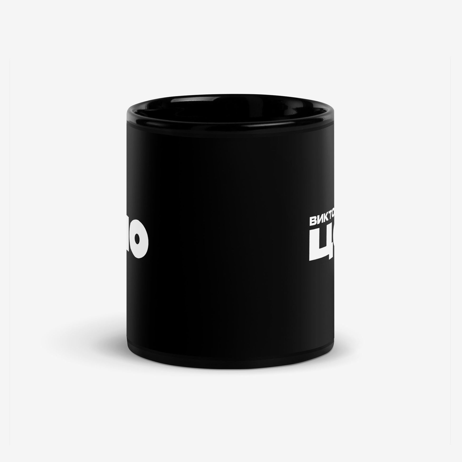 Black coffee mug with bold white КИНО (KINO) band logo. Official Viktor Tsoi Soviet rock merch. Side photo. From www.kinoband.com