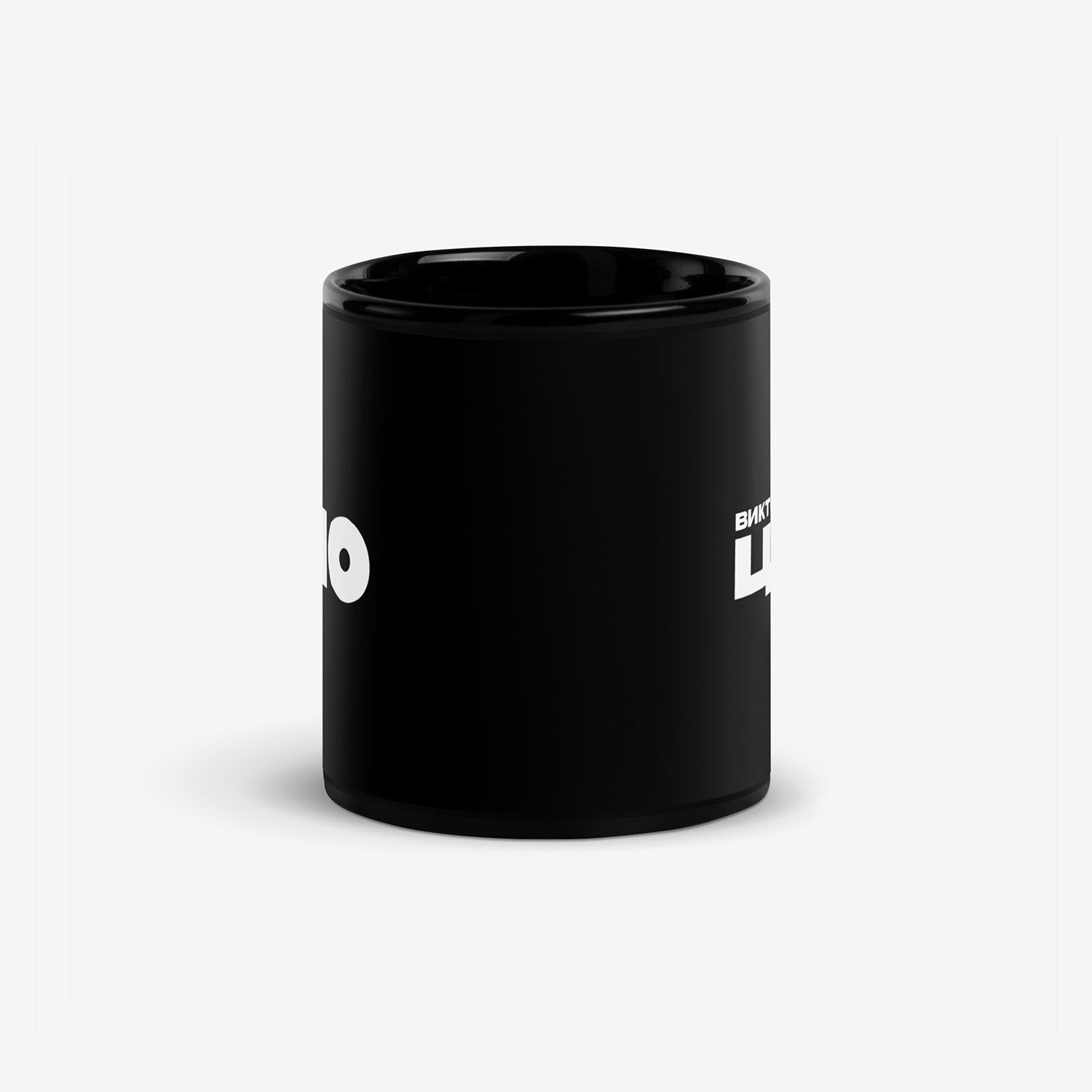 Black coffee mug with bold white КИНО (KINO band) logo on the front and Viktor Tsoi (Виктор Цой) in Cyrillic on the back. Official Viktor Tsoi Soviet rock merch. Side photo. From www.kinoband.com