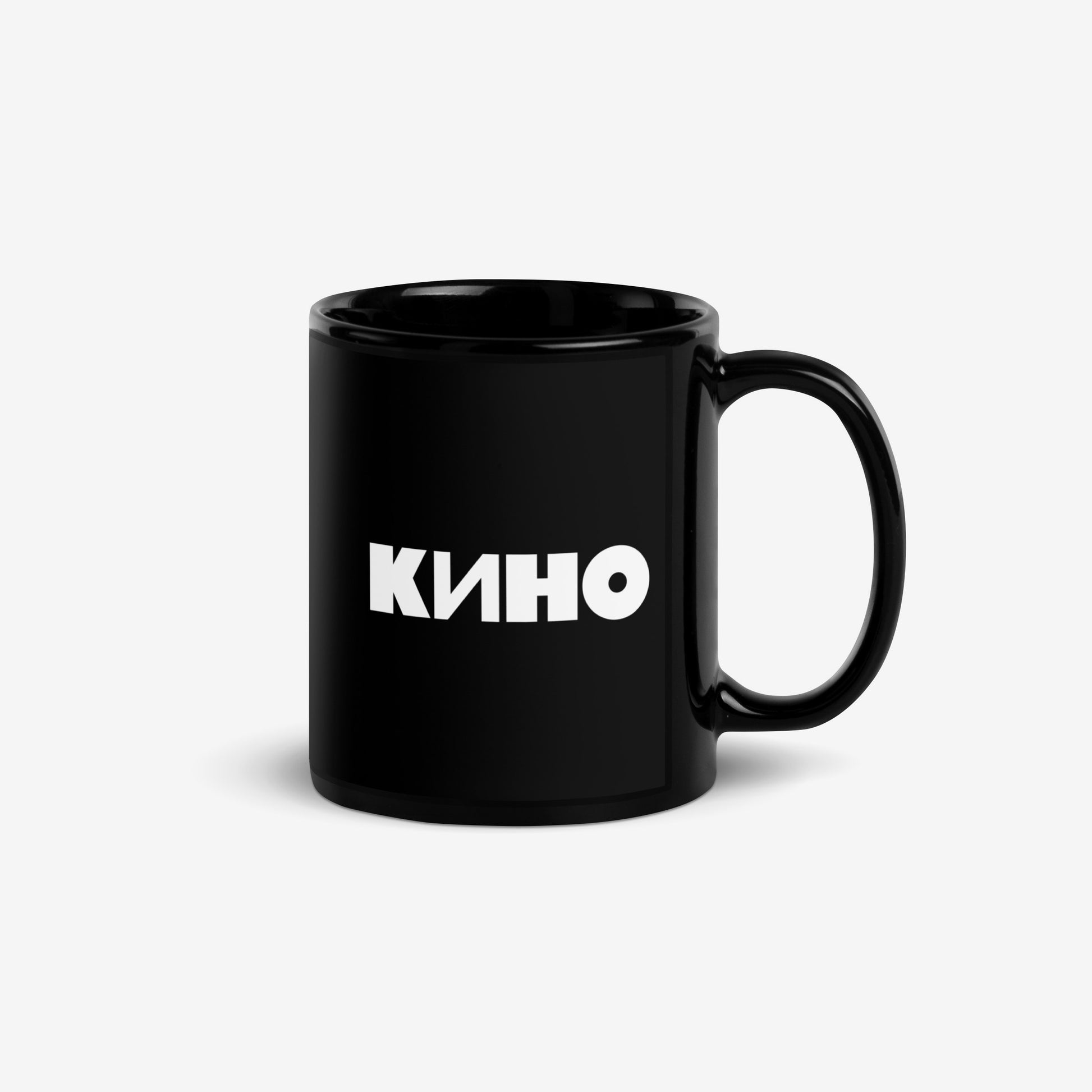 Official KINO Band black mug featuring lyrics in bold russian from a 'Peremen' (Перемен – Change) song by Viktor Tsoi 'Cigarettes in hands, tea on the table' (Сигареты в руках, чай на столе) and КИНО logo on the back. Back side. www.kinoband.com