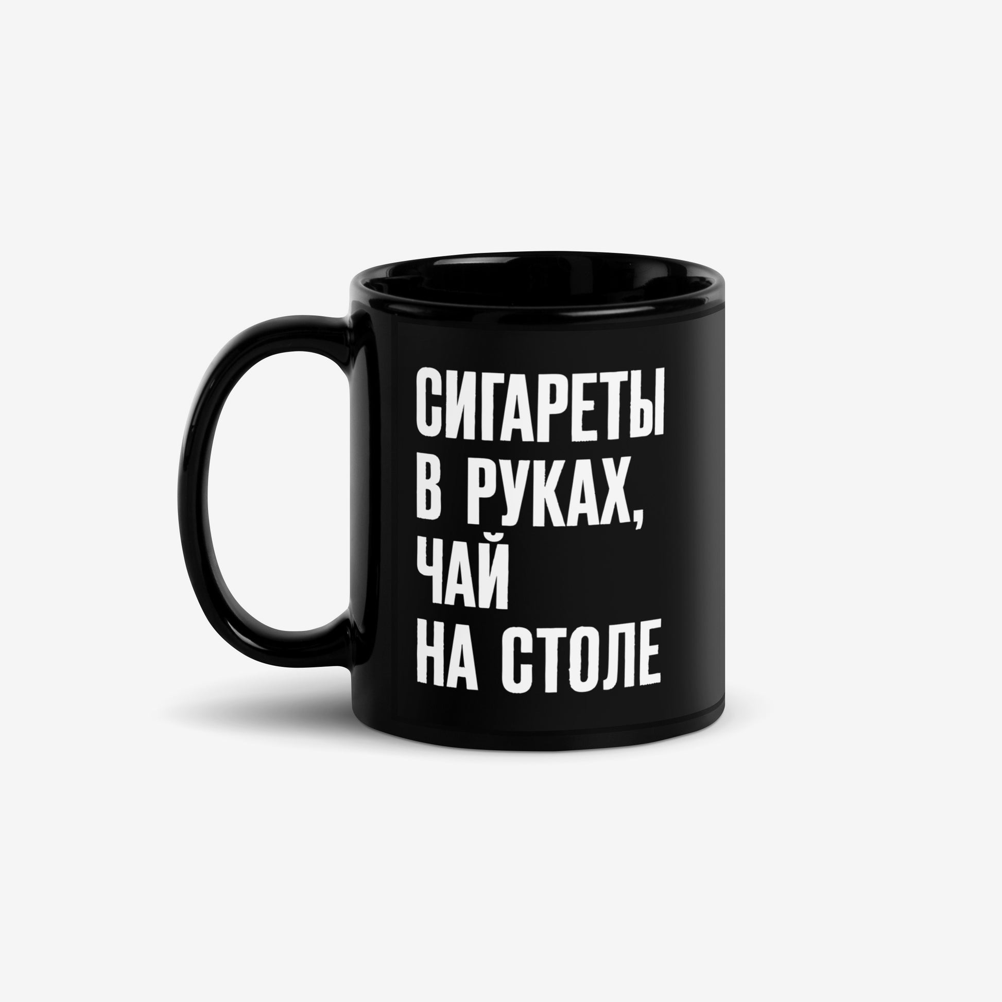 Official KINO Band black mug featuring lyrics in bold russian from a 'Peremen' (Перемен – Change) song by Viktor Tsoi 'Cigarettes in hands, tea on the table' (Сигареты в руках, чай на столе) and КИНО logo on the back. Front side. www.kinoband.com
