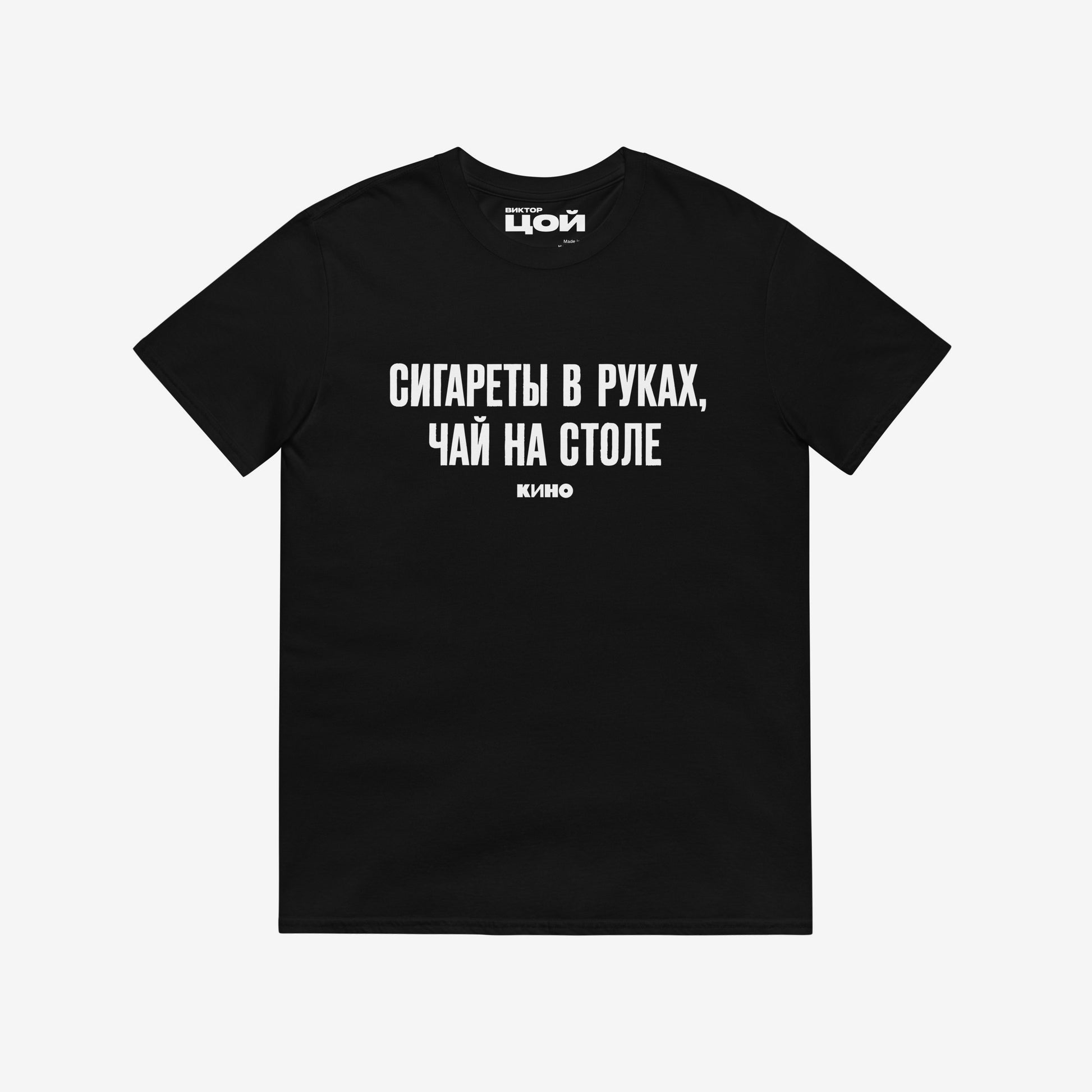 Official KINO Band black unisex T-shirt featuring lyrics in bold russian from a 'Peremen' (Перемен – Change) song by Viktor Tsoi 'Cigarettes in hands, tea on the table' (Сигареты в руках, чай на столе) and КИНО logo underneath. Featuring Виктор Цой logo on the necktag. www.kinoband.com