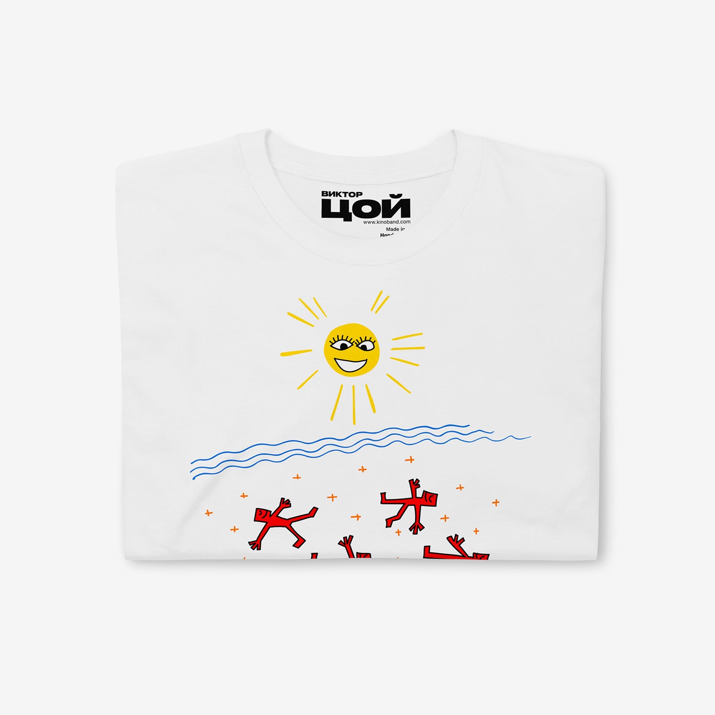 Official KINO band white unisex T-shirt with painting by Viktor Tsoi 'Sun of Beach'. With smiley sun and people on the beach by the water. Folded shirt closeup photo with necktag logo 'Viktor Tsoi' (Виктор Цой) in Cyrillic. From www.kinoband.com