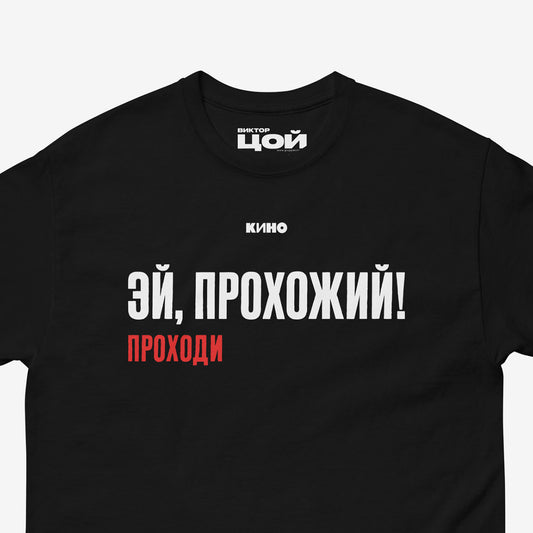 Viktor Tsoi song "Эй, прохожий проходи!" (Hey, passerby, pass by!) printed on the front of a heavyweight black unisex t-shirt with KINO logo, from www.kinoband.com. Closeup photo.