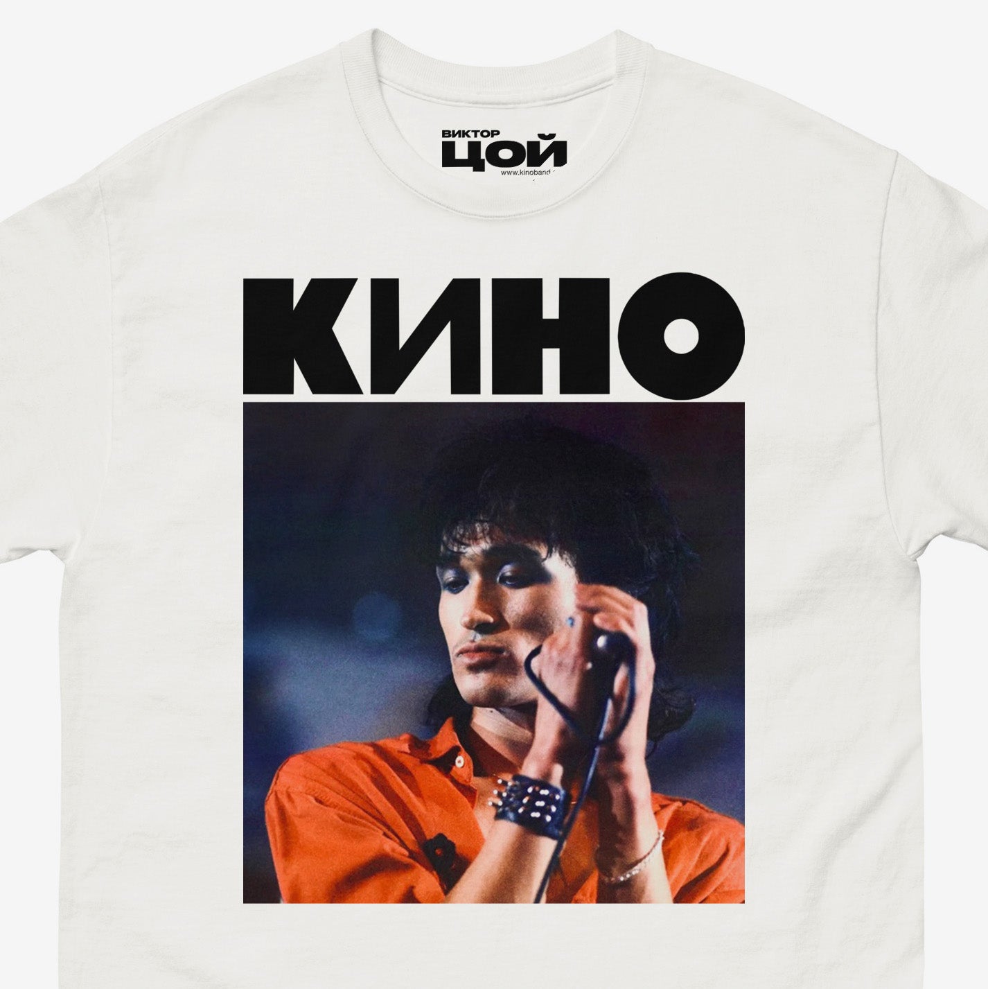 White t-shirt with large photo of Viktor Tsoi performing live and bold KINO band logo above. Closeup photo. From kinoband.com