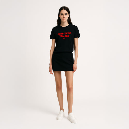 Young sexy girl model in short skirt wearing black T-shirt with KINO band lyrics “Любовь стоит того, чтобы ждать”. Original Viktor Tsoi merch from www.kinoband.com