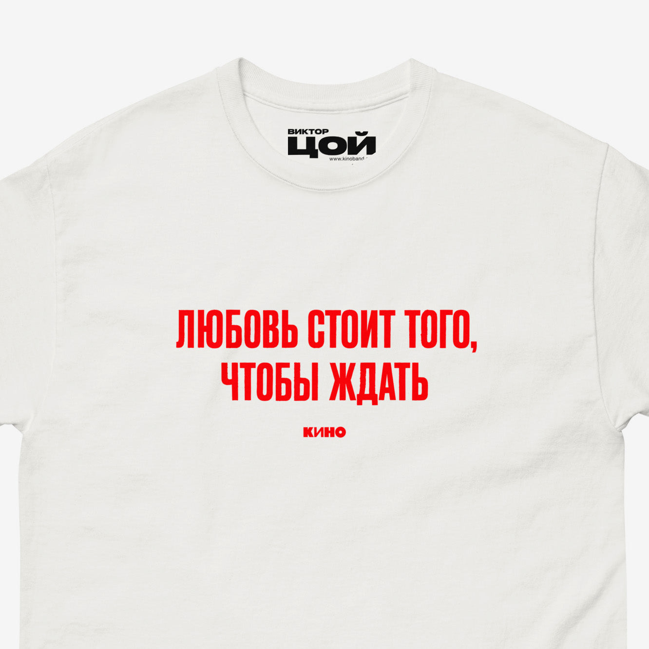 White T-shirt with KINO band lyrics “Любовь стоит того, чтобы ждать”. Closeup photo with visible necktag design. Original Viktor Tsoi merch from www.kinoband.com