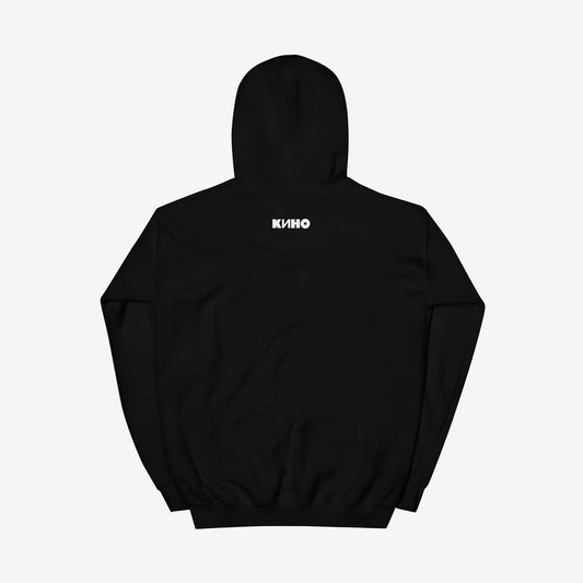 Rare archival photo of Viktor Tsoi in a yellow T-shirt against a white brick wall with a little KINO band logo under the photo, printed on the front of a heavyweight quality black unisex hoodie with a KINO logo on the back neck side, from www.kinoband.com. Back side.