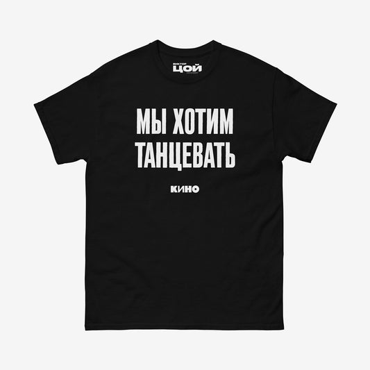 Black T-shirt with white Cyrillic KINO band song lyric 'We wanna dance' and KINO logo underneath. Viktor Tsoi merch from www.kinoband.com